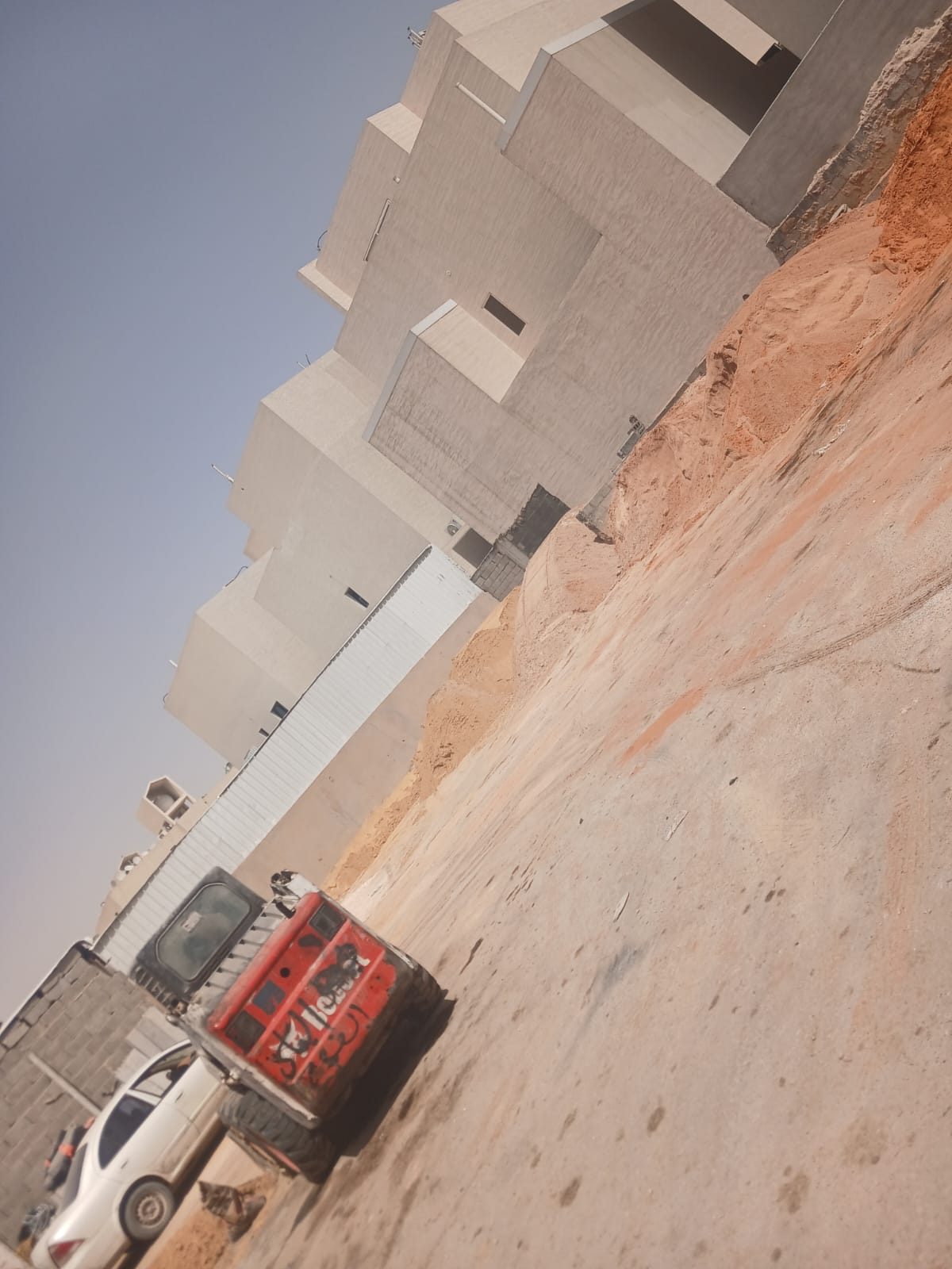 توريد مواد بناء إلى موقع عمل في الرياض بجانب مبنى تحت الإنشاء