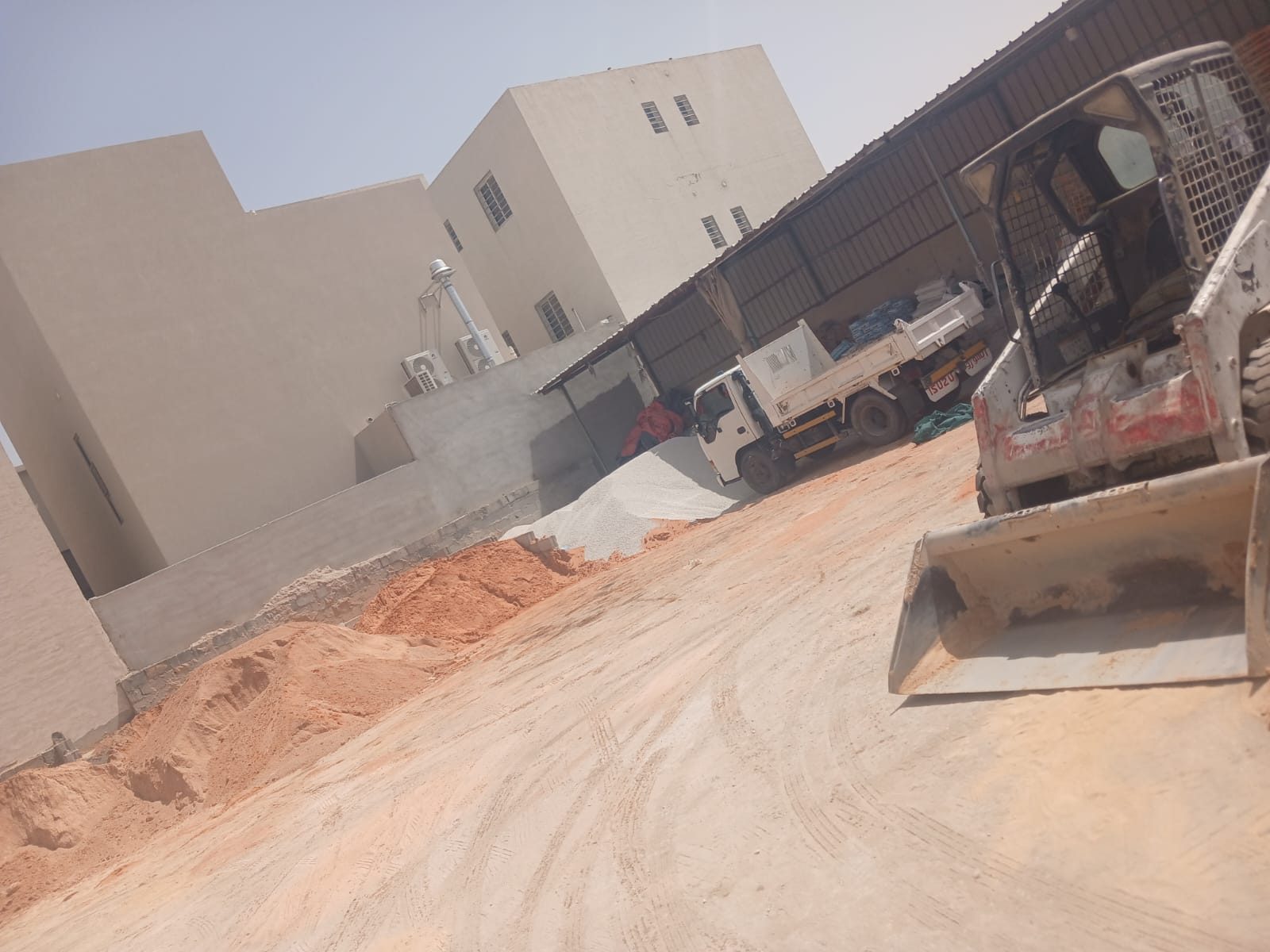 ساحة مبسط امجاد: شاحنة قلاب ولودر وأكوام رمل جاهزة للتحميل